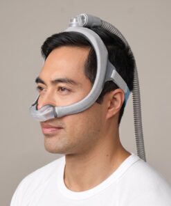 Hombre usando la mascarilla nasal CPAP ResMed AirTouch N30i con el tubo conectado en la parte superior de la cabeza y el campo visual despejado