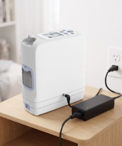 Concentrador de oxígeno portátil Inogen One G5 conectado a la fuente de poder AC BA-501 y enchufado a la corriente en casa