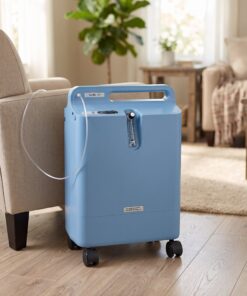 Concentrador de oxígeno Philips Respironics EverFlo OPI instalado en una sala de estar, con cánula nasal junto a un sillón, en un ambiente hogareño tranquilo