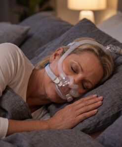 Persona durmiendo de costado con la mascarilla ResMed AirFit F30i, con la manguera desviada por arriba para mayor libertad de movimiento