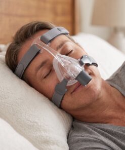 Hombre descansando tranquilo en la cama con la mascarilla nasal CPAP React Health Viva puesta