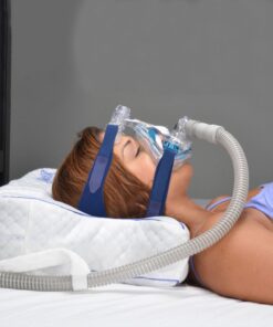 Persona durmiendo de lado con máscara CPAP apoyada en la almohada ergonómica